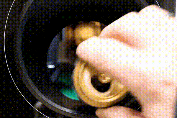 an animated gif of a person's hand putting cans into a DRS machine.